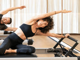 a woman in black outfit doing pilates
